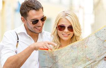 Imagem de casal jovem olhando mapa.